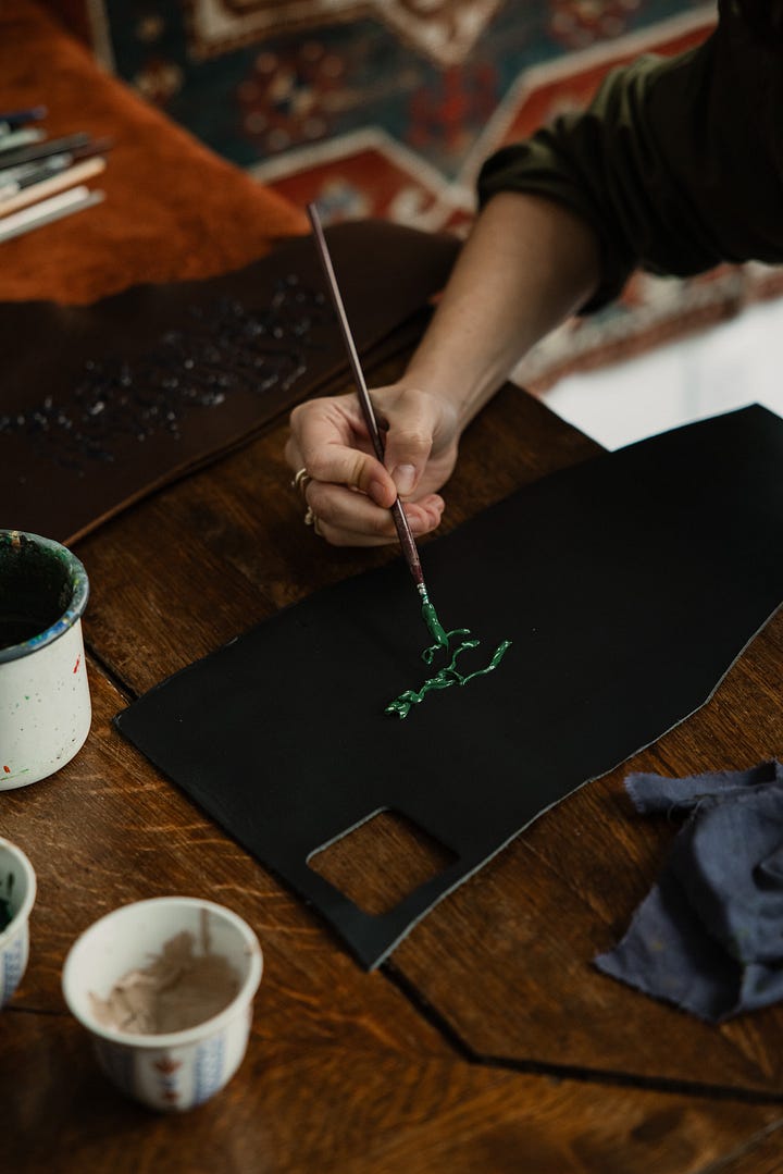 Farah Alimi painting on leather pieces at Paramaz in Paris