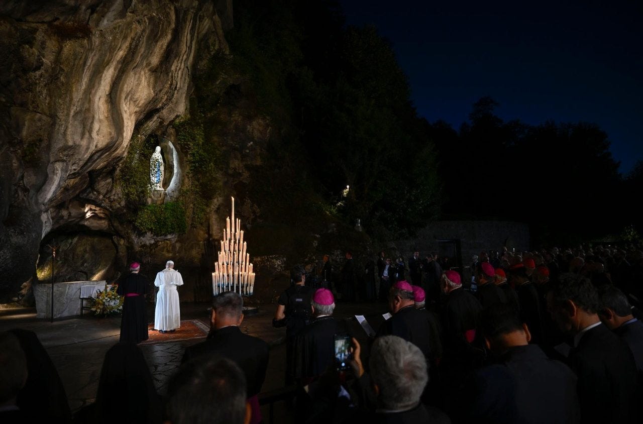 Pope Leo XIV prays at the Grotto of Massabielle at nightfall