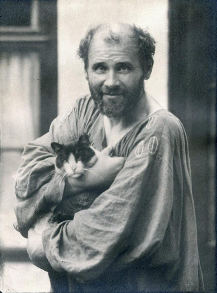 Photograph of Gustav Klimt with a cat in his studio smock Photograph of Gustav Klimt with a cat in his studio smock
