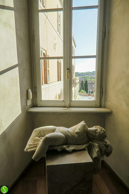 photo of Roman statue resting on pedestal in museum in Rome. Photo by Steve Butcher 2025