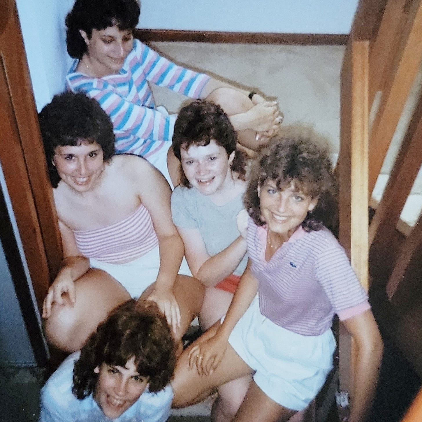 Five college-aged girls posed on stairs like it's a publicity photo for a hit sitcom