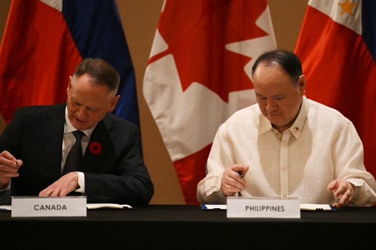Philippines' Secretary of National Defence Gilberto Teodoro (R) and Canadian Minister of Defence David McGuinty sign documents of the visiting forces agreement after their bilateral meeting in Manila on November 2, 2025. [Ted Aljibe/AFP]