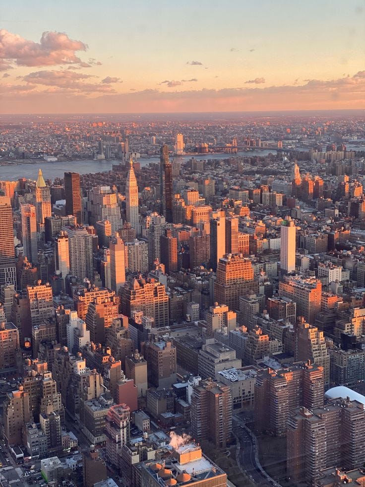 This may contain: an aerial view of new york city at sunset