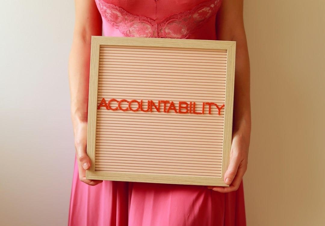 Woman holds a sign reading "accountability."