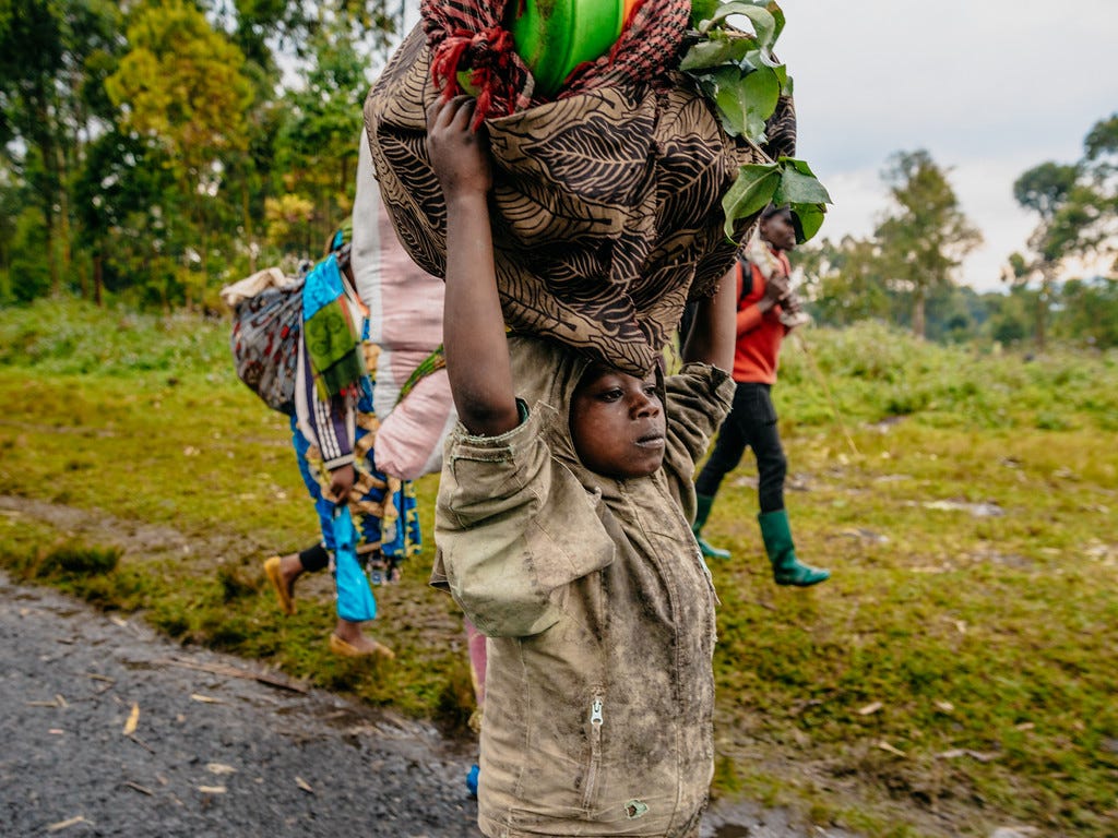 A newly displaced family fleeing with their belongings towards Goma A newly displaced family fleeing with their belongings towards Goma