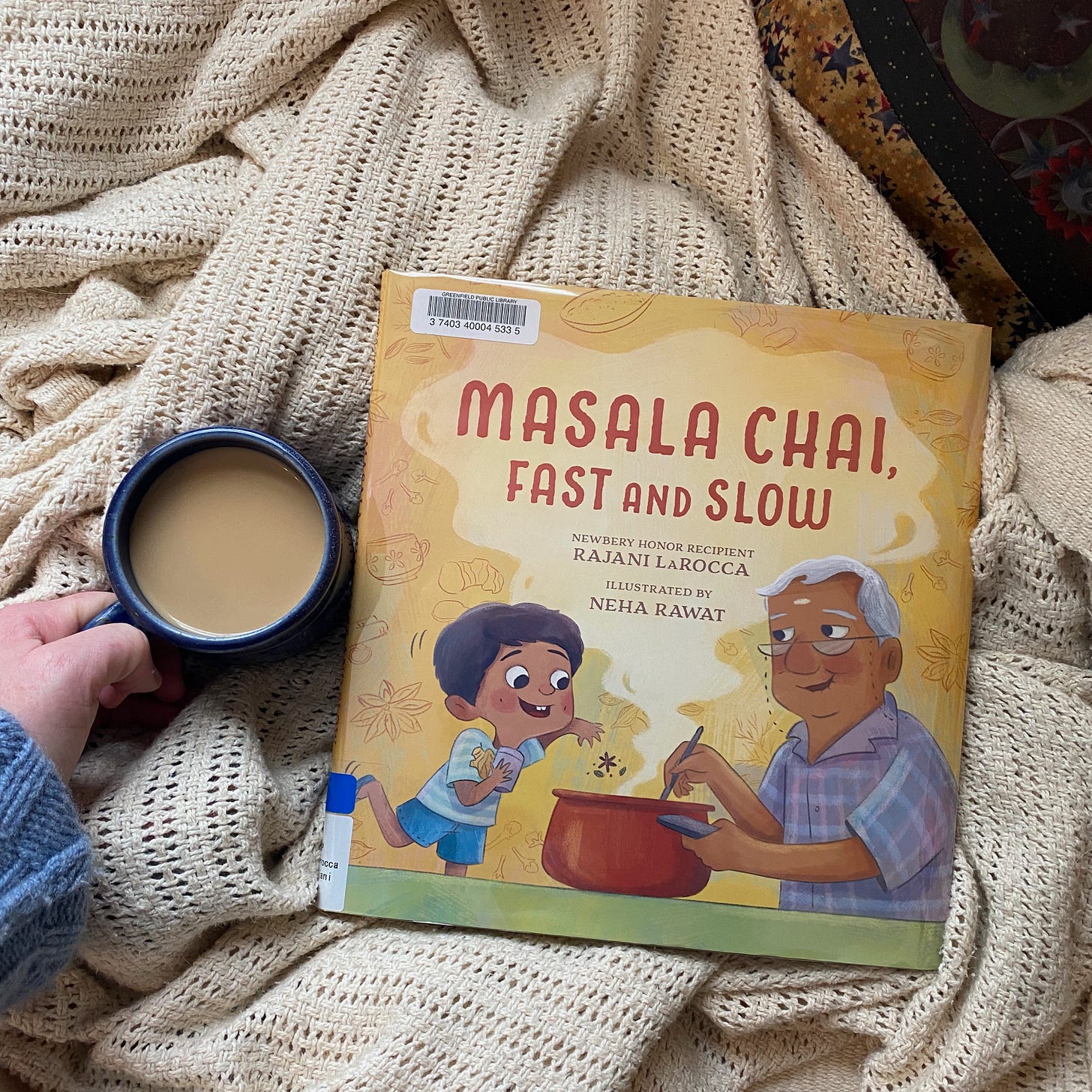 Masala Chai, Fast and Slow, on a white blanket next to a mug of chai.