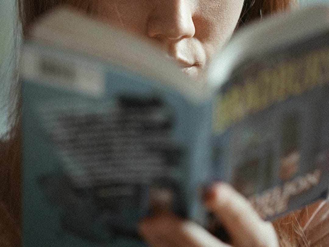 woman holding magazine with womans face woman holding magazine with womans face