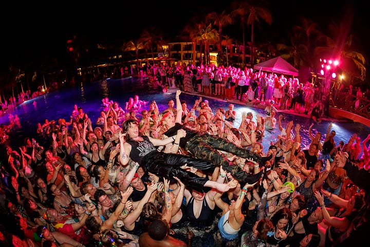 Brandi Carlile and Megan Falley crowd-surfing in a pool, fully clothed, full of joy.