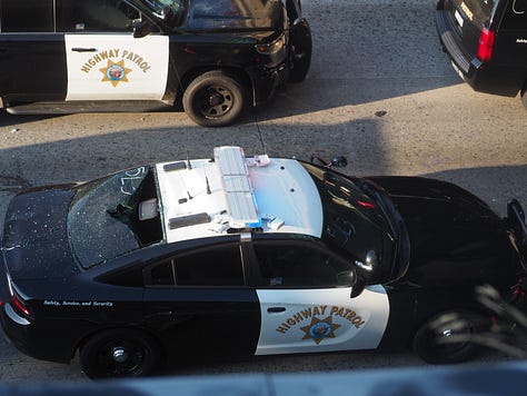 Protesters begin vandalizing police vehicles that are parked on the 101 freeway.