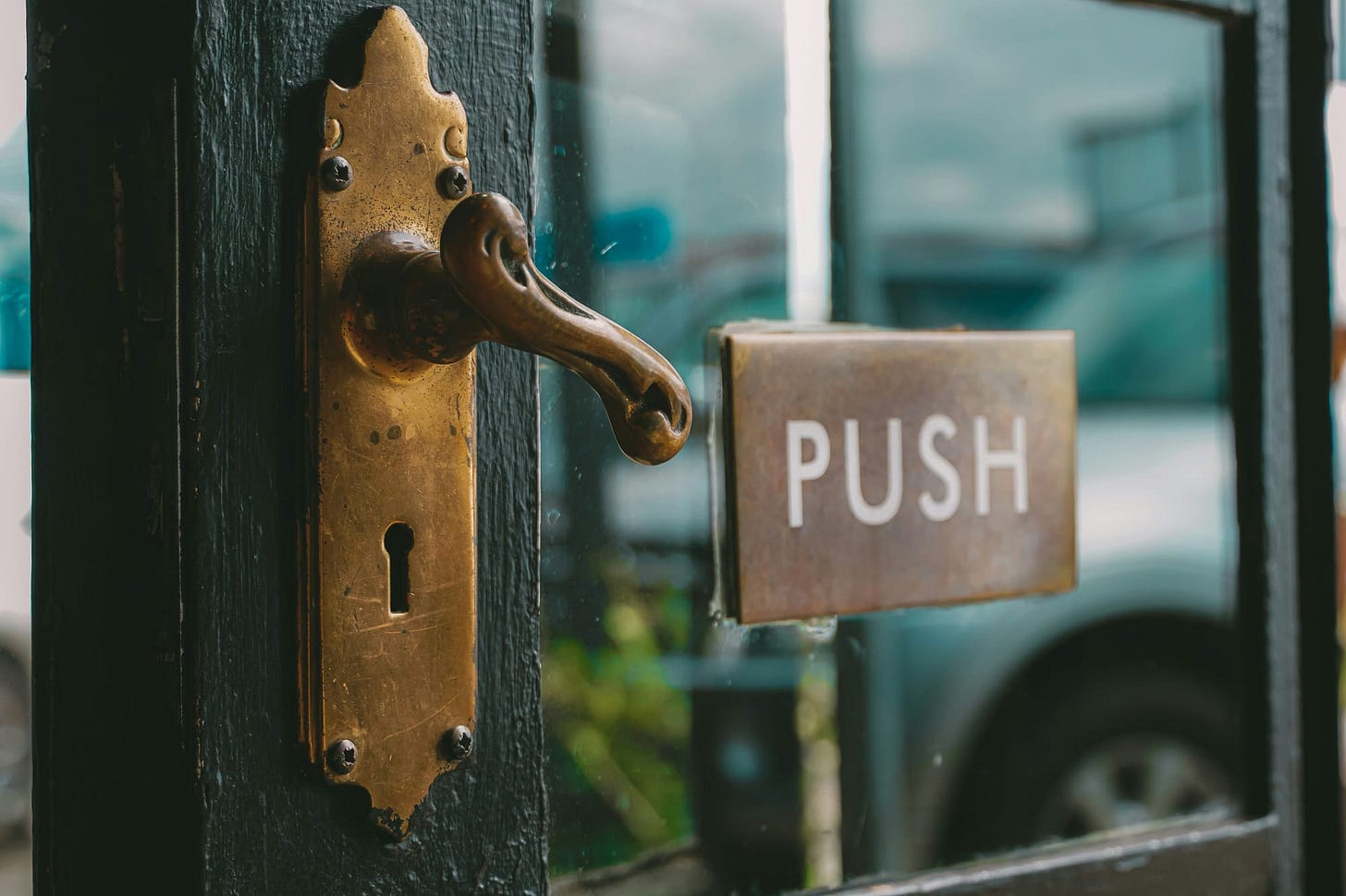 Door, slightly ajar, with a sign that reads "Push" Door, slightly ajar, with a sign that reads "Push"