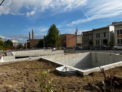 Photo of machinery on a construction site and new foundations being poured.
