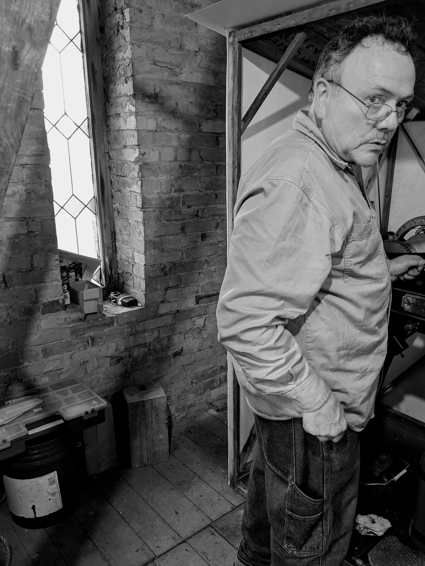 Man working inside a clock tower.
