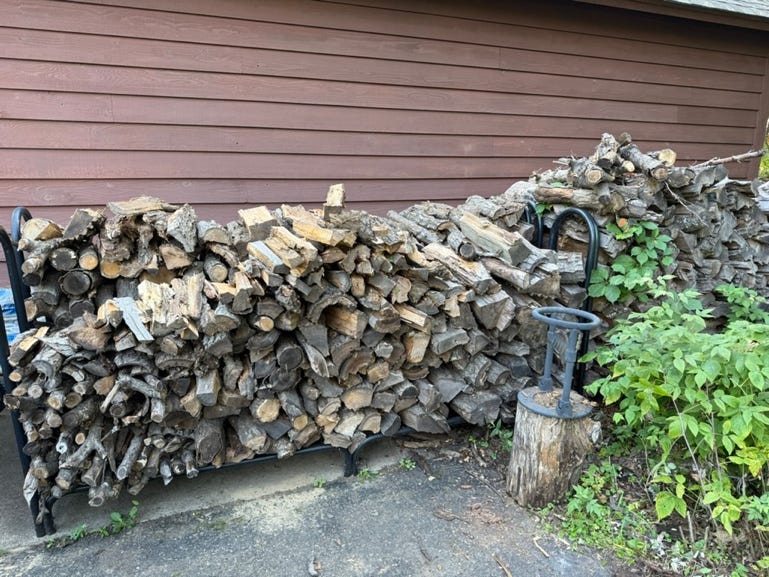 A stack of wood next to a building

AI-generated content may be incorrect.