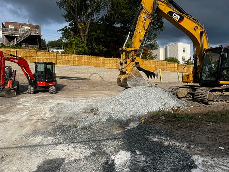 Photo of machinery on a construction site and new foundations being poured.