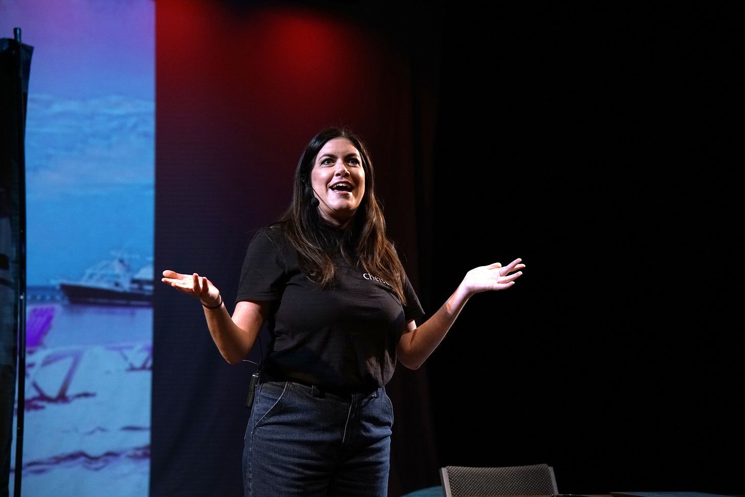 Hannah Petersen, a white woman, stands on stage as she performs in her play Vacate.