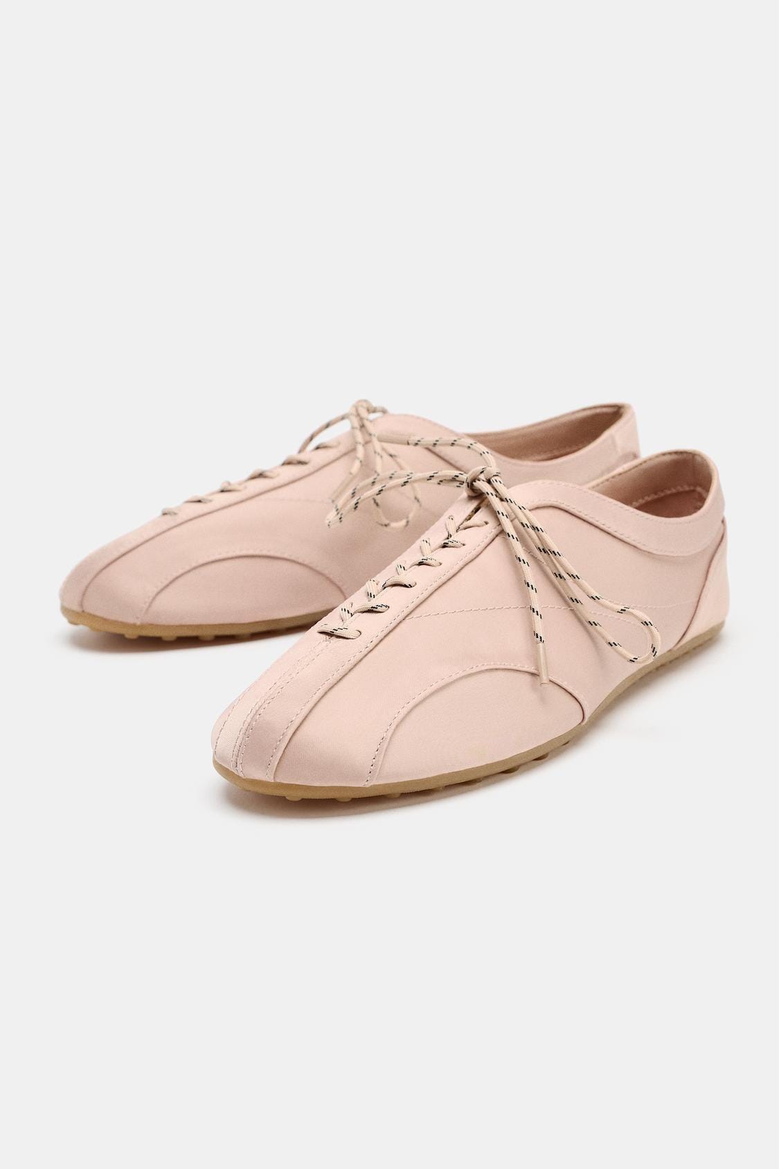Beige footwear with two-tone laces and a rubber sole. It features a design with decorative stitching and a rounded toe. Beige footwear with two-tone laces and a rubber sole. It features a design with decorative stitching and a rounded toe.