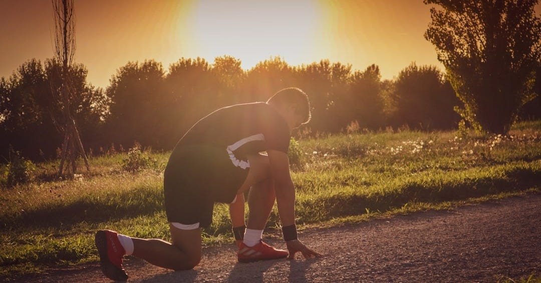 a person kneeling on a dirt road