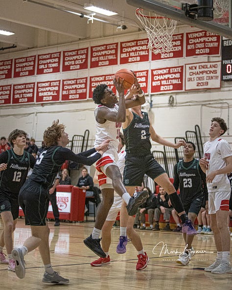 Five pictures of CVU boys basketball players in various stages of leaping and shooting with the ball. White uniforms with red lettering.