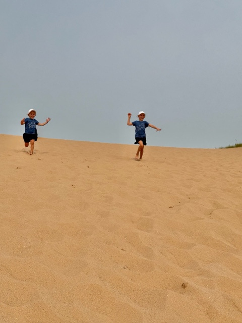 A couple of kids running down a sand hill

AI-generated content may be incorrect.