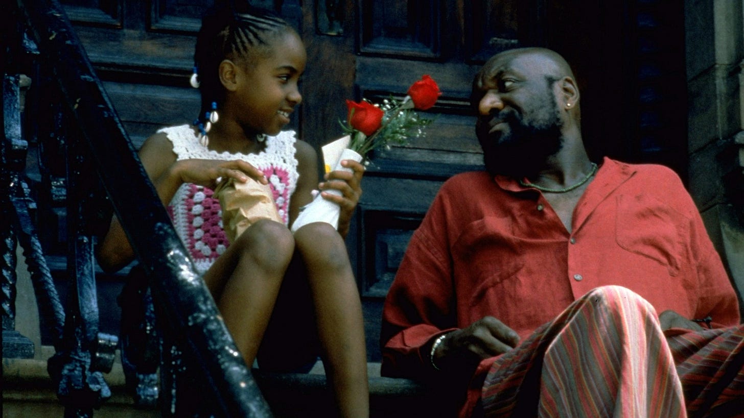 Crooklyn | Still features Zelda Harris as Troy, carrying flowers while looking happily at Delroy Lindo's Woody.