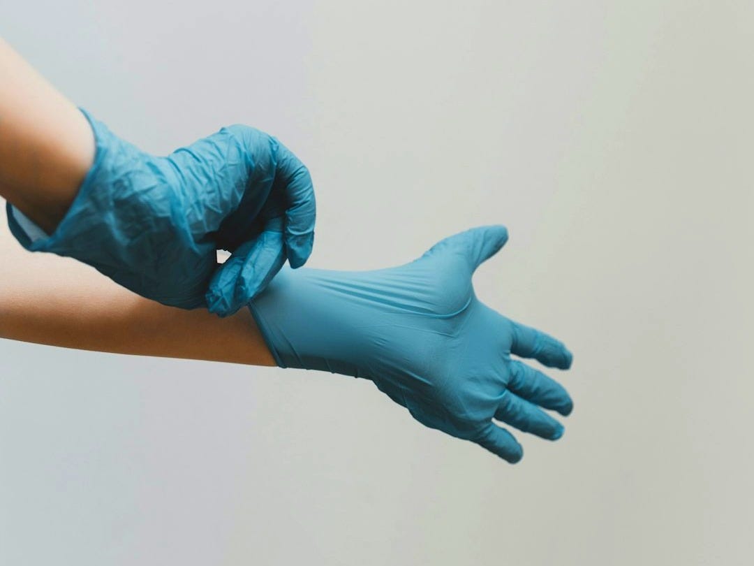 person in blue gloves and blue denim jeans