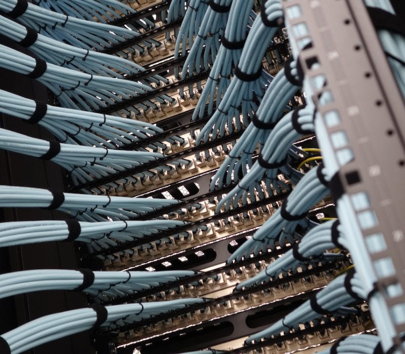 network-rack-with-blue-fiber-optic-cables-connectors-closeup