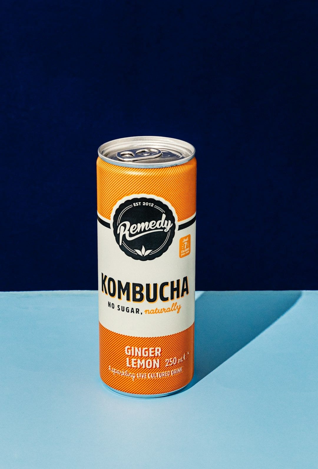 a can of kombucha on a blue surface a can of kombucha on a blue surface