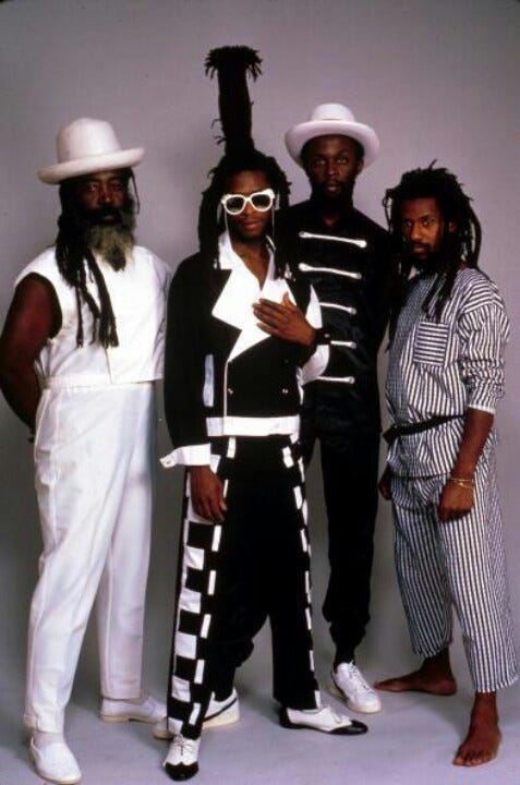 This may contain: three men standing next to each other wearing white hats and black and white striped pants