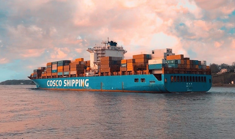 blue cargo ship on sea under cloudy sky during daytime blue cargo ship on sea under cloudy sky during daytime