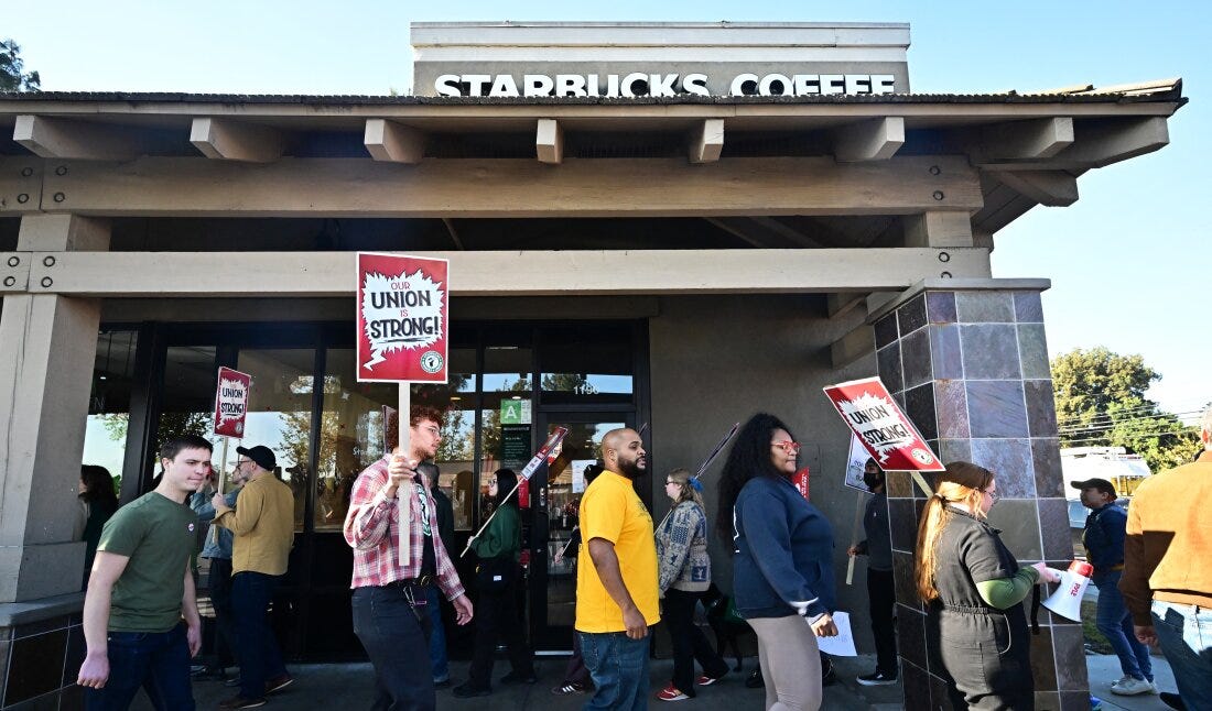 Starbucks workers hold signs as they picket in Burbank, California on Friday. Starbucks workers hold signs as they picket in Burbank, California on Friday.