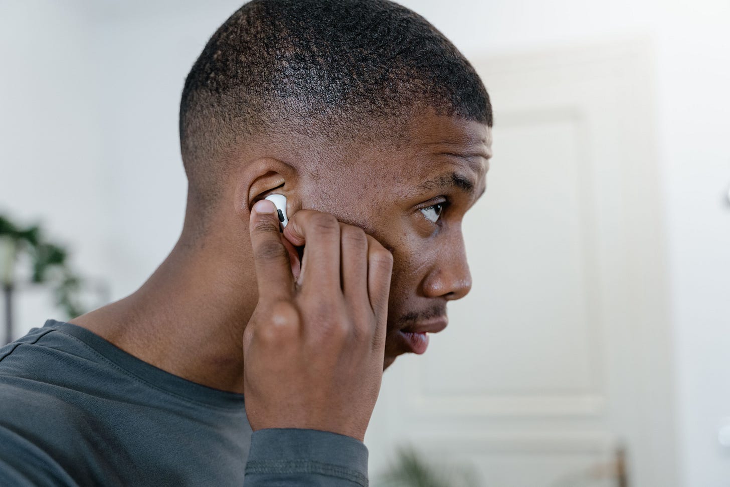 A man adjusting an AirPods Pro earbud in his right ear. A man adjusting an AirPods Pro earbud in his right ear.