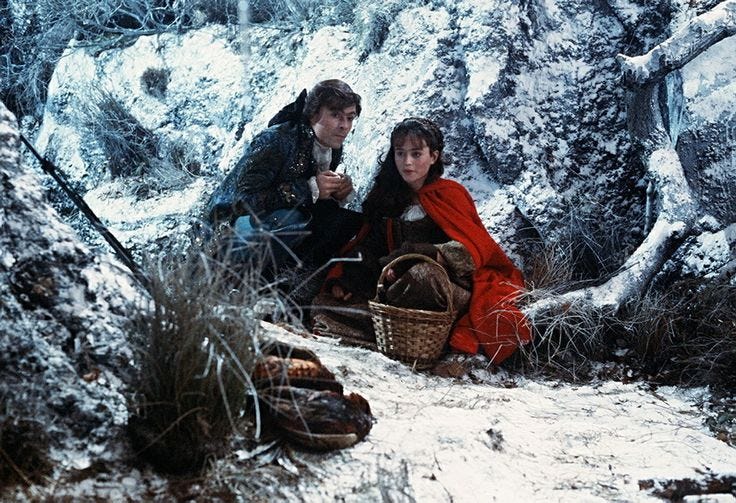 This may contain: two people sitting on the ground in the snow