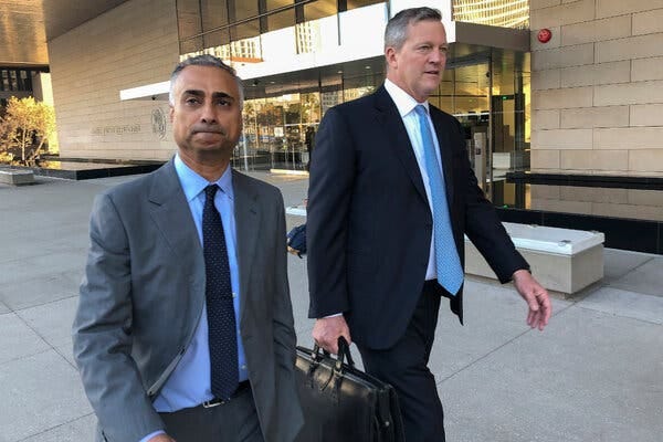 Two men walking outside a courthouse. One is holding a briefcase. Two men walking outside a courthouse. One is holding a briefcase.