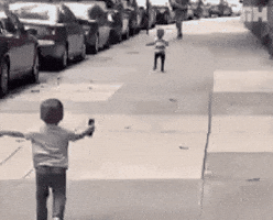 Video gif. Two small boys, about three or four years old, run to each other on a sidewalk, arms spread wide and embrace. Video gif. Two small boys, about three or four years old, run to each other on a sidewalk, arms spread wide and embrace.