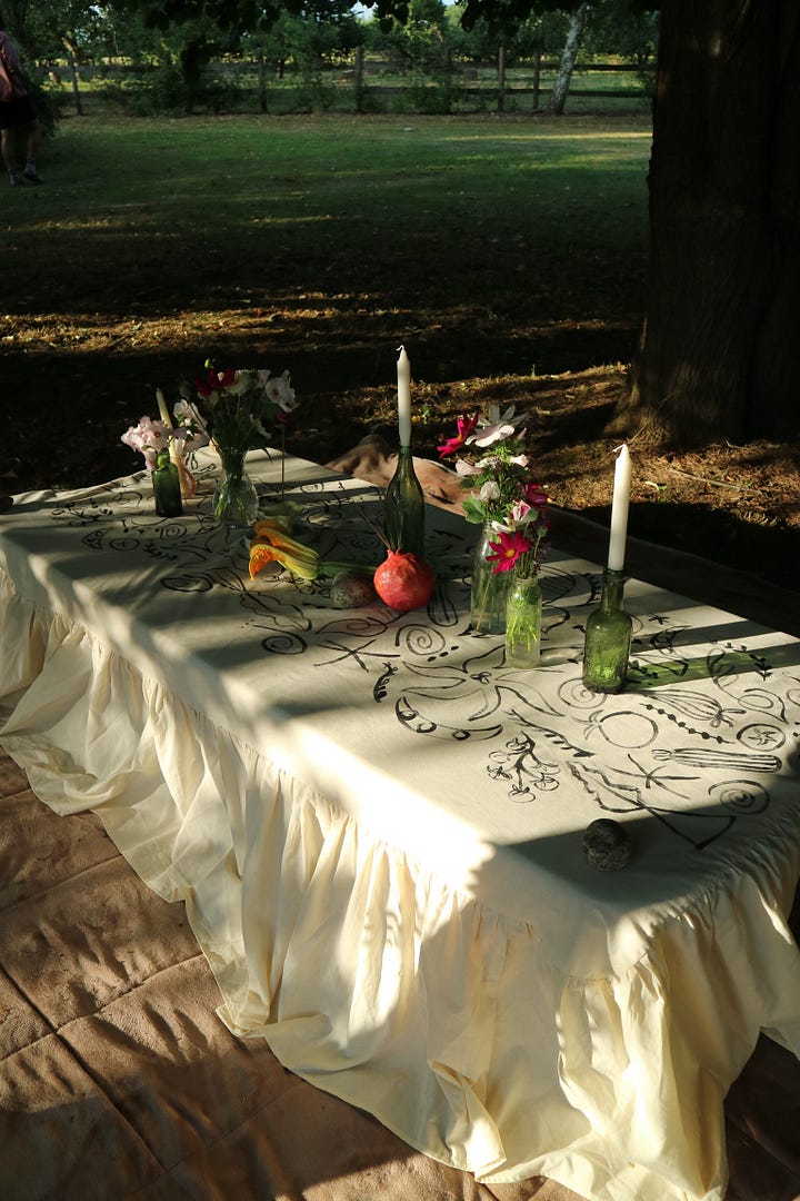 Painting the tablecloth with produce motifs to celebrate the abundance of the garden