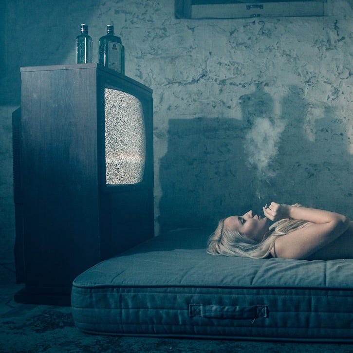woman lying on bed with gray blanket woman lying on bed with gray blanket