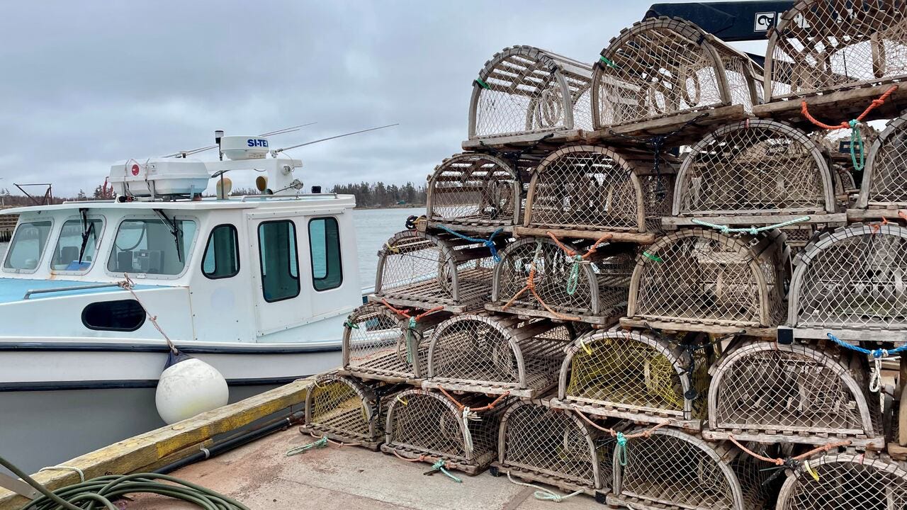 A lobster boat at the wharf, the traps stacked and ready A lobster boat at the wharf, the traps stacked and ready