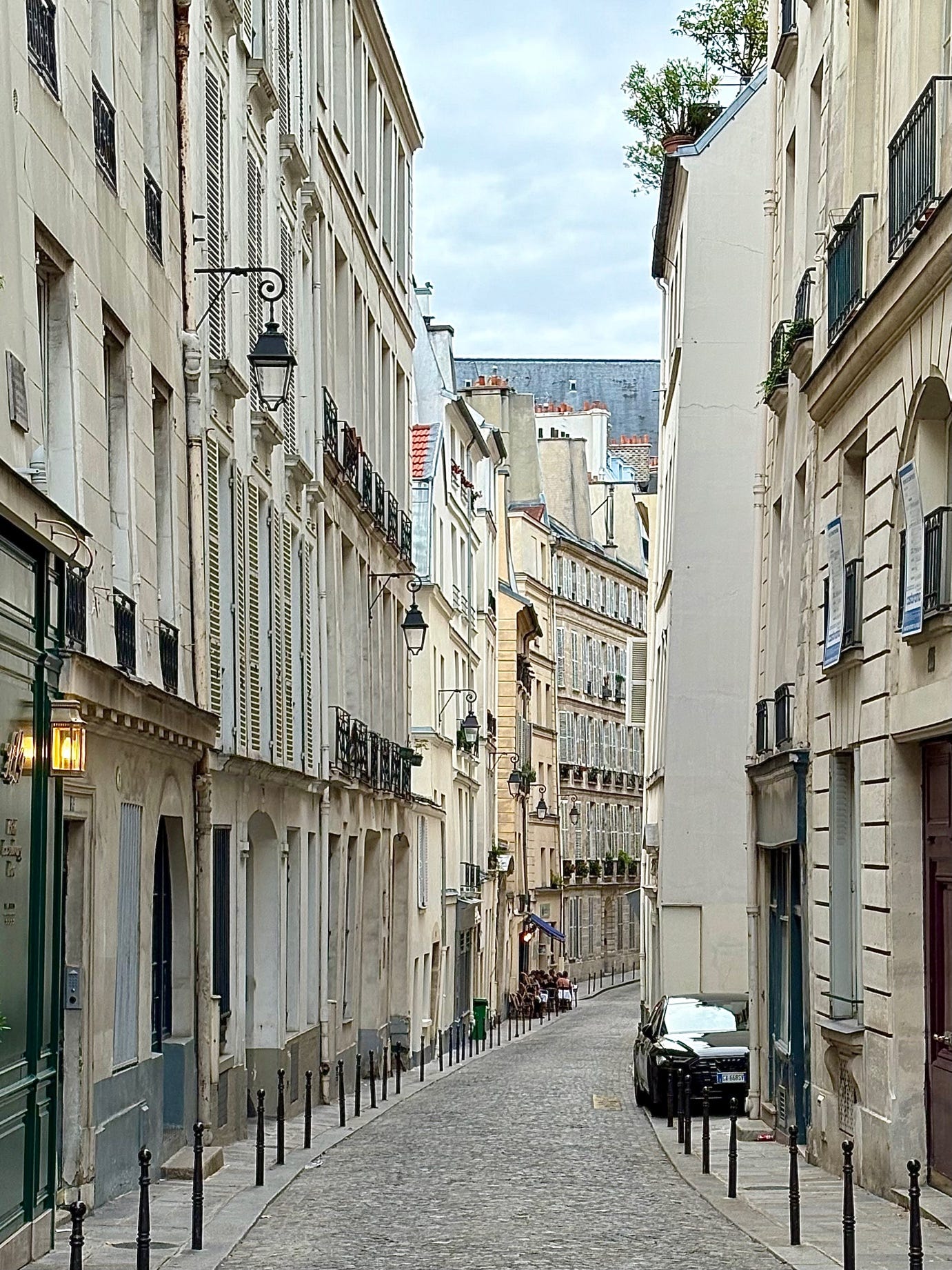 A narrow street with buildings and cars

AI-generated content may be incorrect.