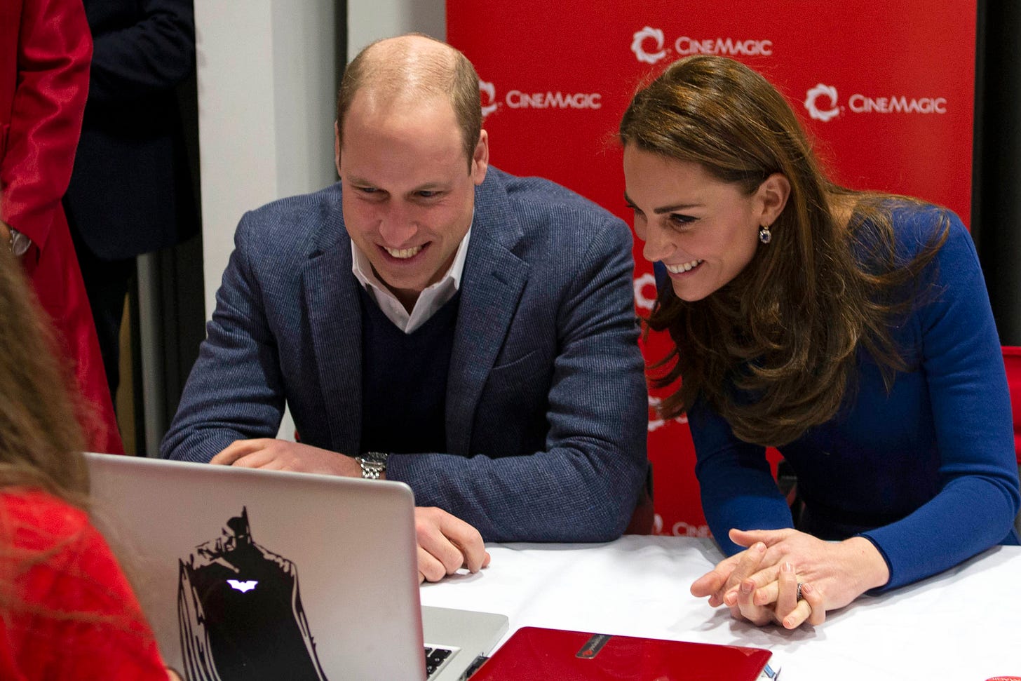 Prince William and Princess Catherine smiling at a laptop