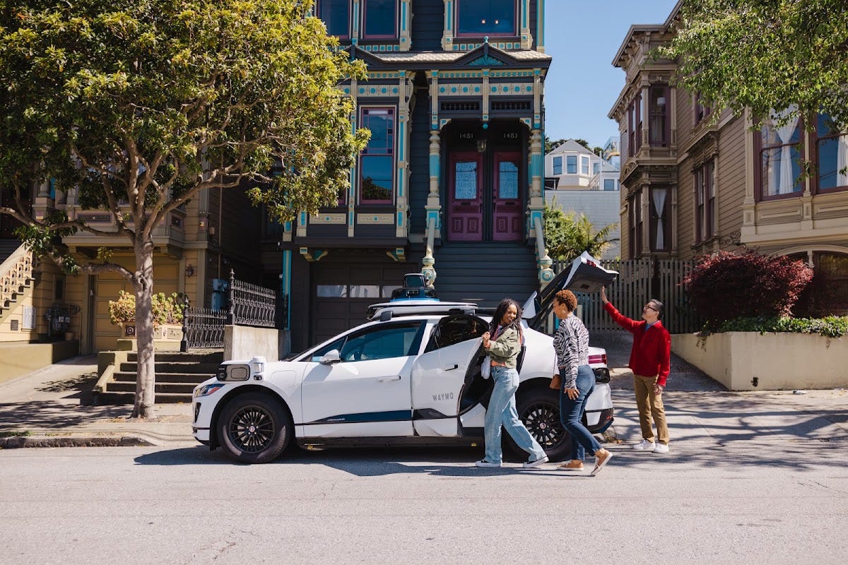A Waymo autonomous vehicle picking up riders on a San Francisco street A Waymo autonomous vehicle picking up riders on a San Francisco street