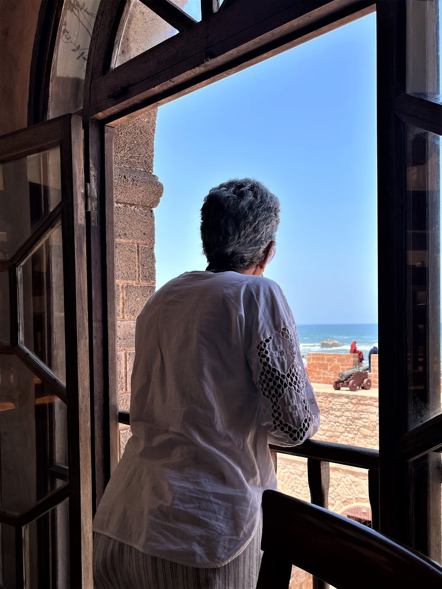 A person looking out a window

Description automatically generated
