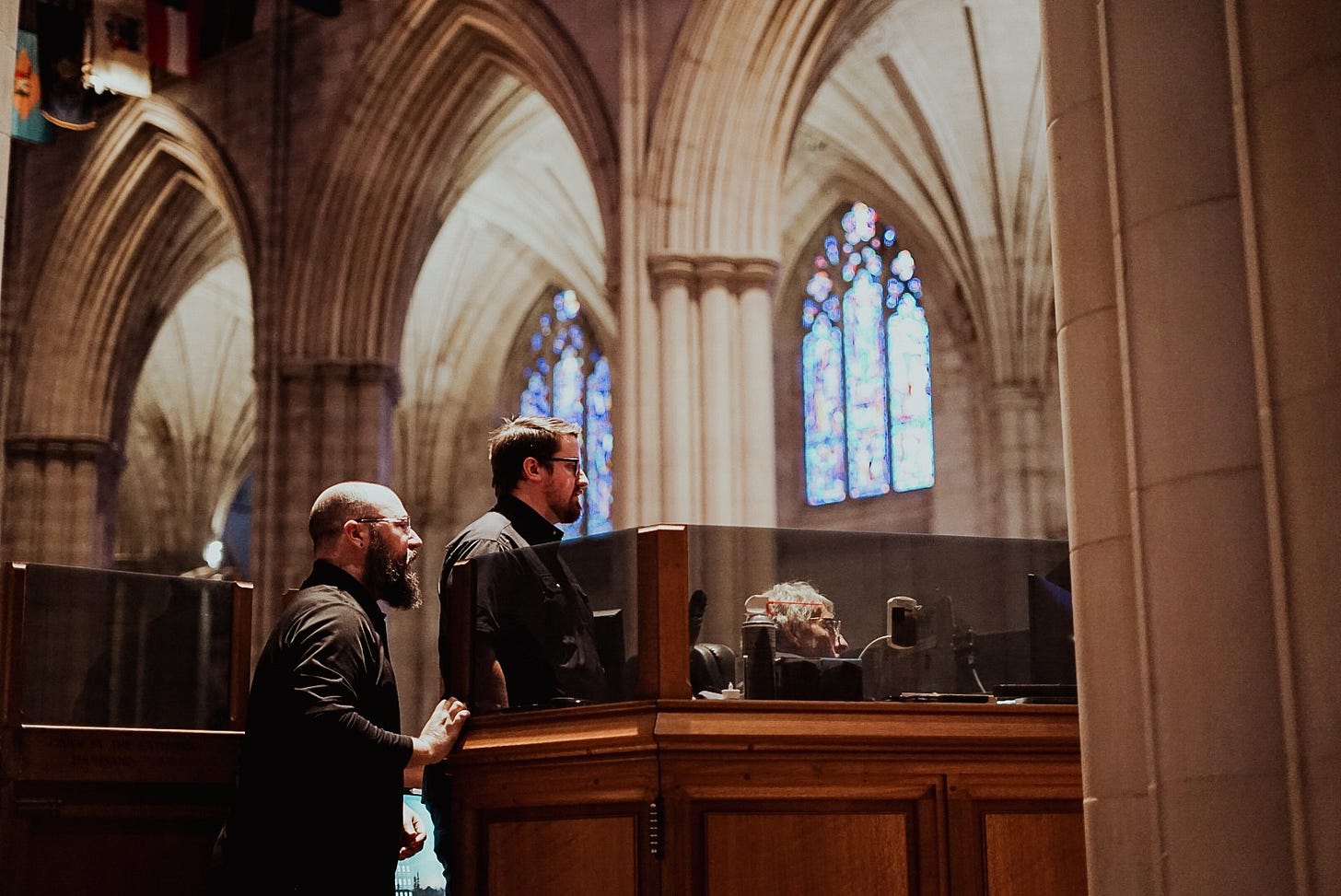Three men shown in the cathedral sound booth.