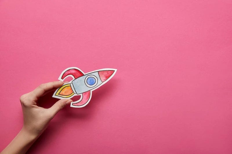 Sales Kickoff Themes concept paper rocketing flying against a pink background