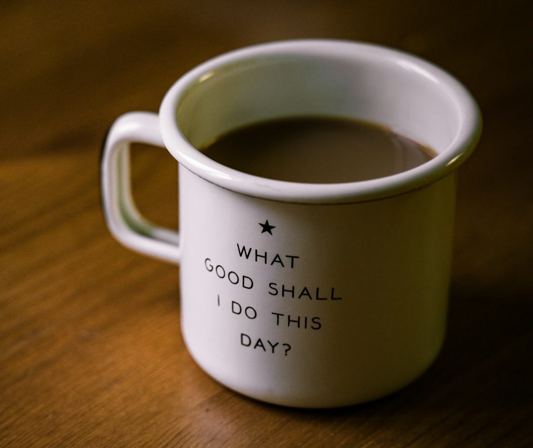 white and black ceramic cup filled with brown liquid on brown wooden sufface