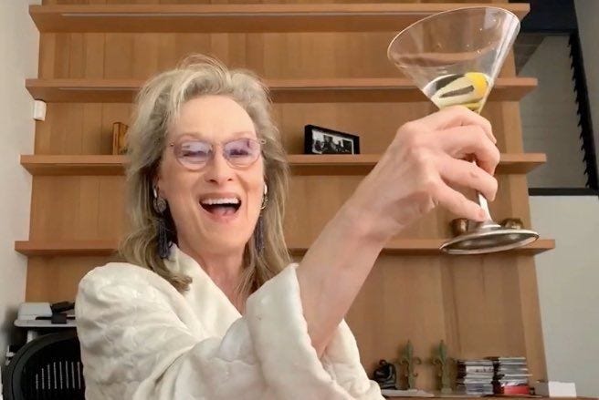 This may contain: an older woman holding up a wine glass