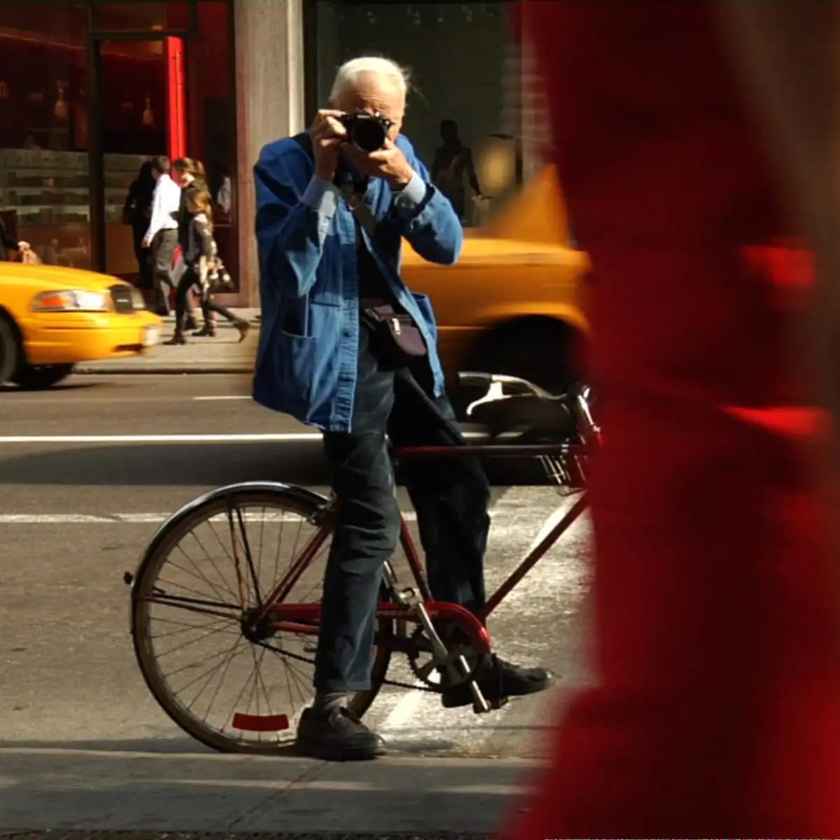 May be an image of 4 people, people standing, bicycle, umbrella, street and text