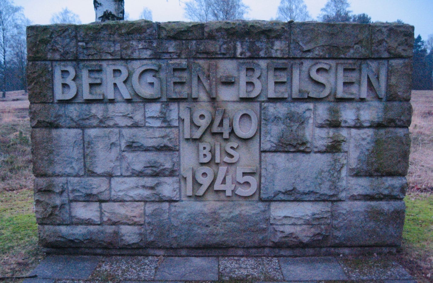 A stone wall with a sign

Description automatically generated