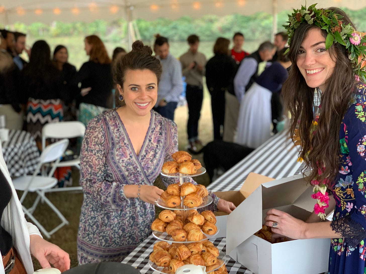 A photo of myself and my friend Polina standing around a tower of mini pan au chocolat at my wedding celebration