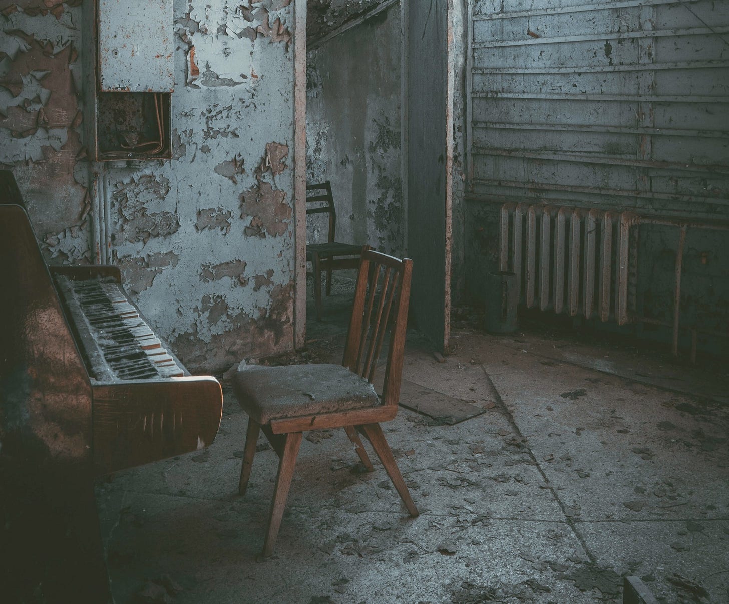 Dilapidated room featuring a chair in front of a piano Dilapidated room featuring a chair in front of a piano