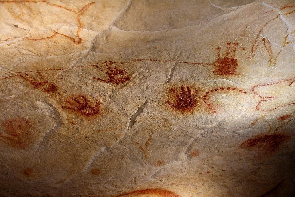 A cave painting of hands and people

AI-generated content may be incorrect.